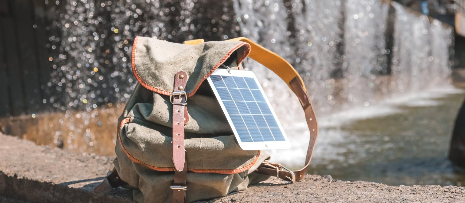 Portable solar panel.Traveler uses green energy to charge gadgets.Eco crisis,eo friendly,sustainable