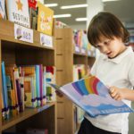 Young Boy Reading Children Story Book in Library